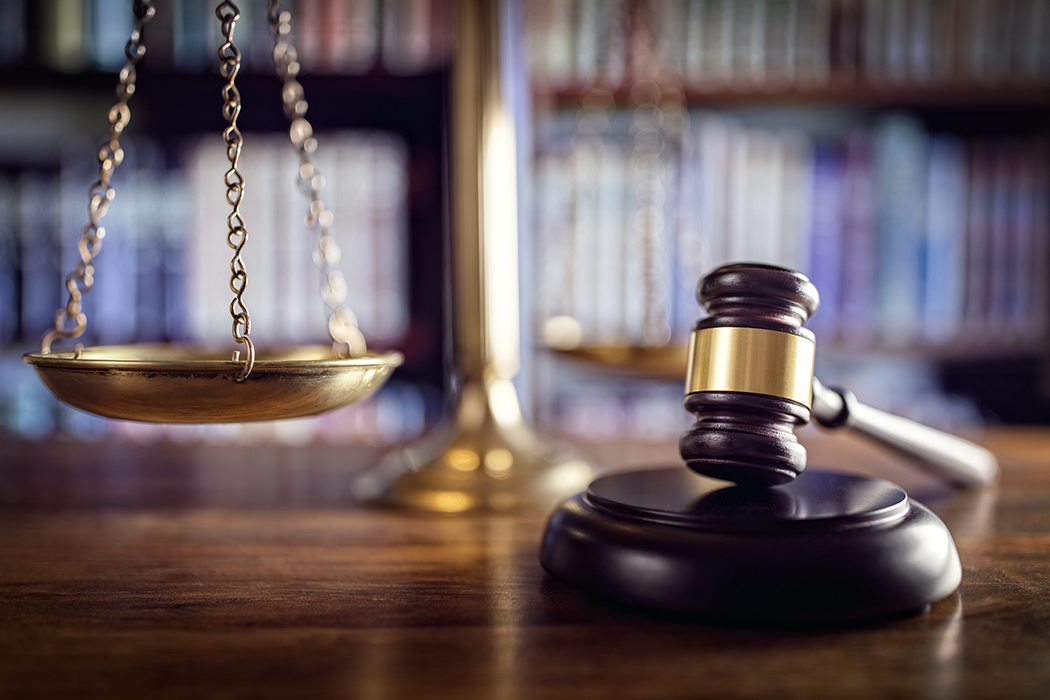 Judge's gavel, scales of justice, and law books in court