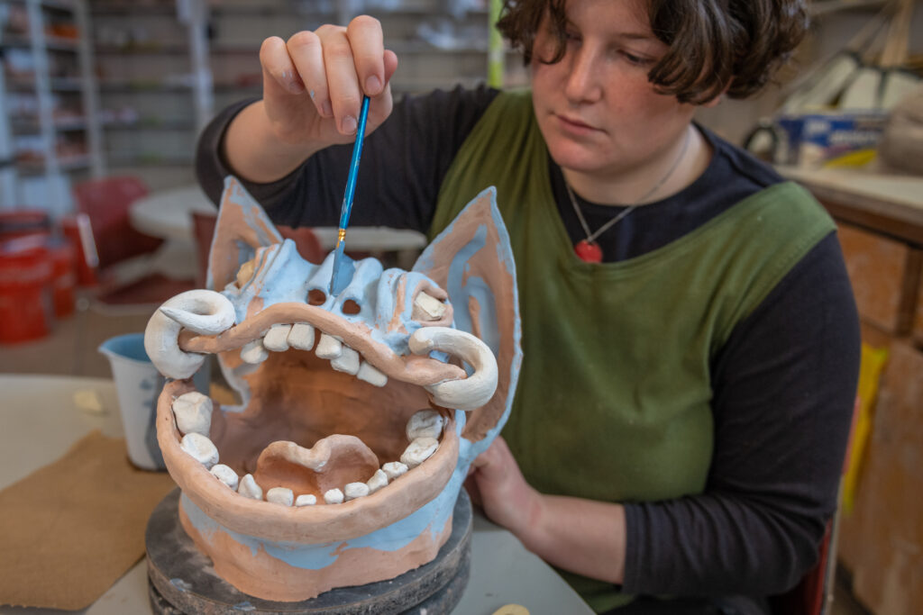 Brynn Keevil '23 created clay gargoyle heads in Clark's craft studio.