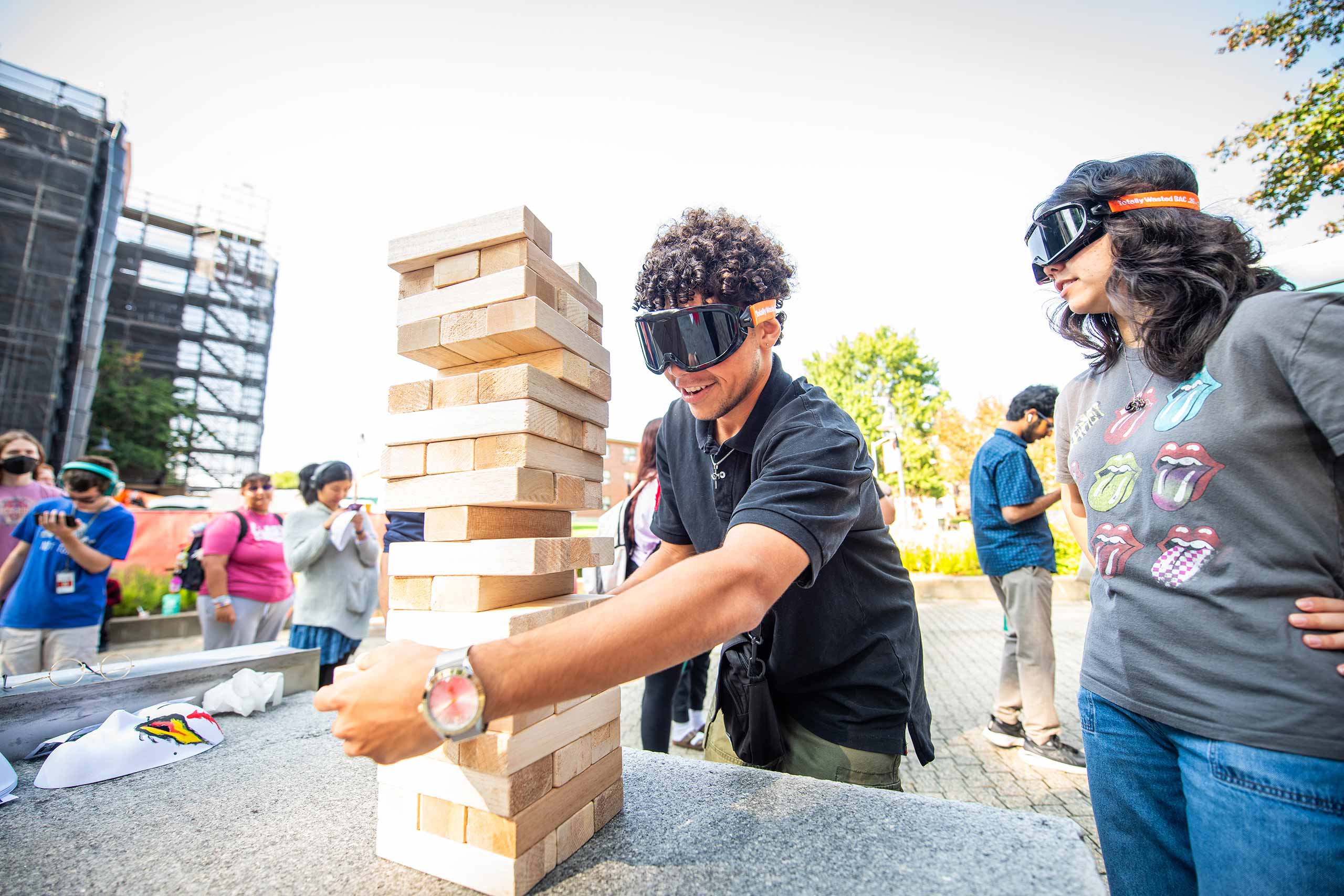 Students wearing dark eye gear participate in a Jenga-like activity during #FreshCheckDay, Clark University