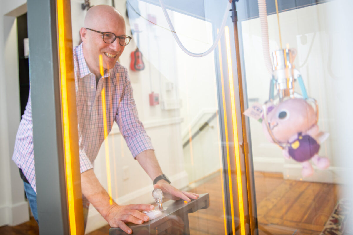 Gary Goldberger, president of Fablevision, plays a claw machine game.