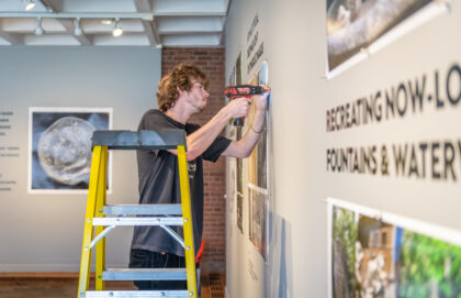 Dan Gillooly '25 helps hang Professor John Garton's Digital Bomarzo Show.