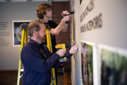 Professor and student hang photos