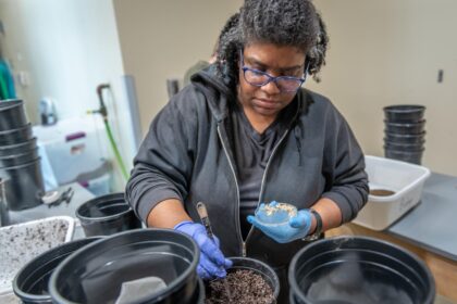 professor in front of buckets of soil