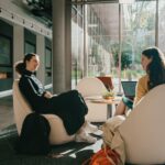 Two students sitting in chairs talking