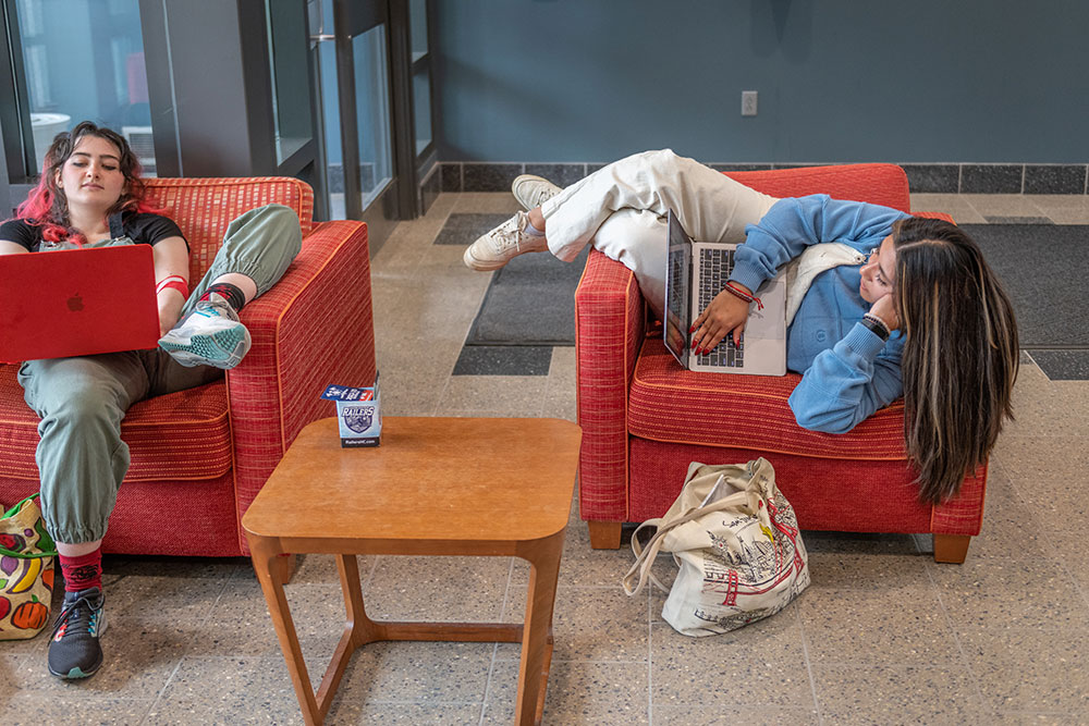 Students studying in the chairs in the Lasry Common area