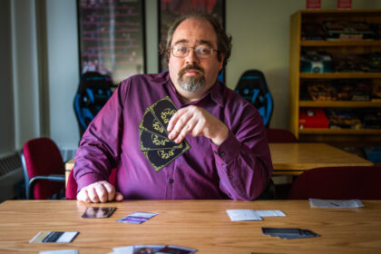 Professor Nevin Flanagan holding card game cards
