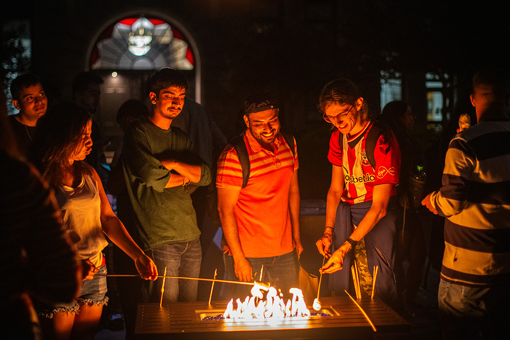 Students gathering around a fire for Saturday evening fun.
