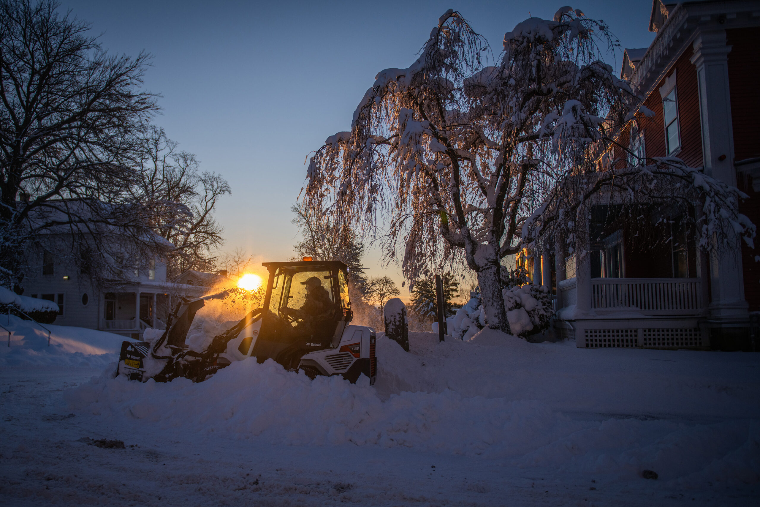A Facilities Management worker clears snow at Clark University
