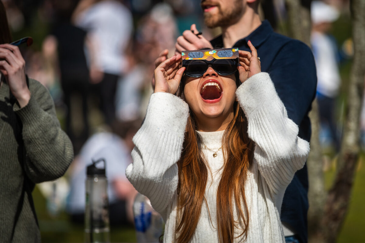 Students watch the partial solar eclipse on April 8, 2024, on the Clark University campus