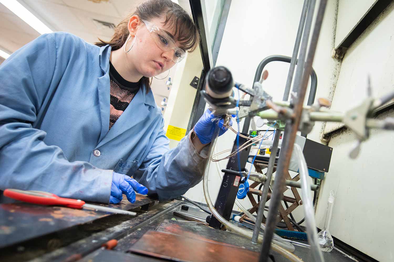 Student working with mechanical equipment in a lab, Clark University
