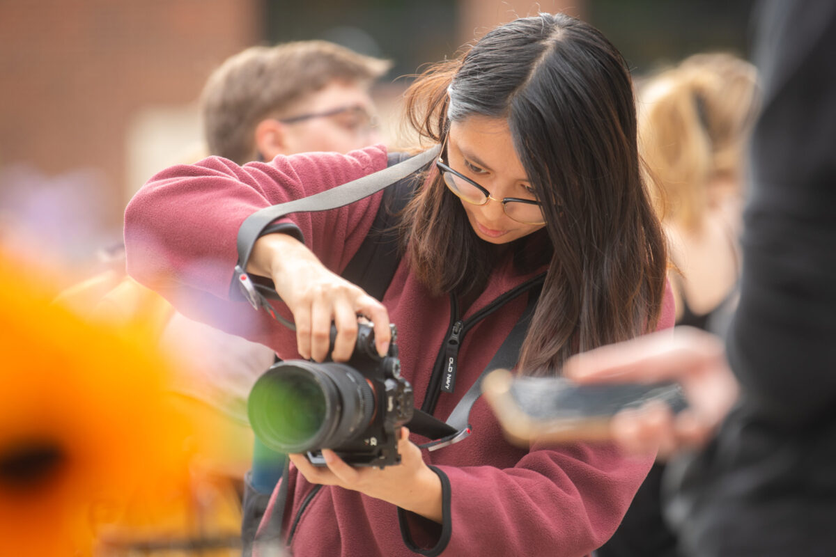 student holds camera to take photo