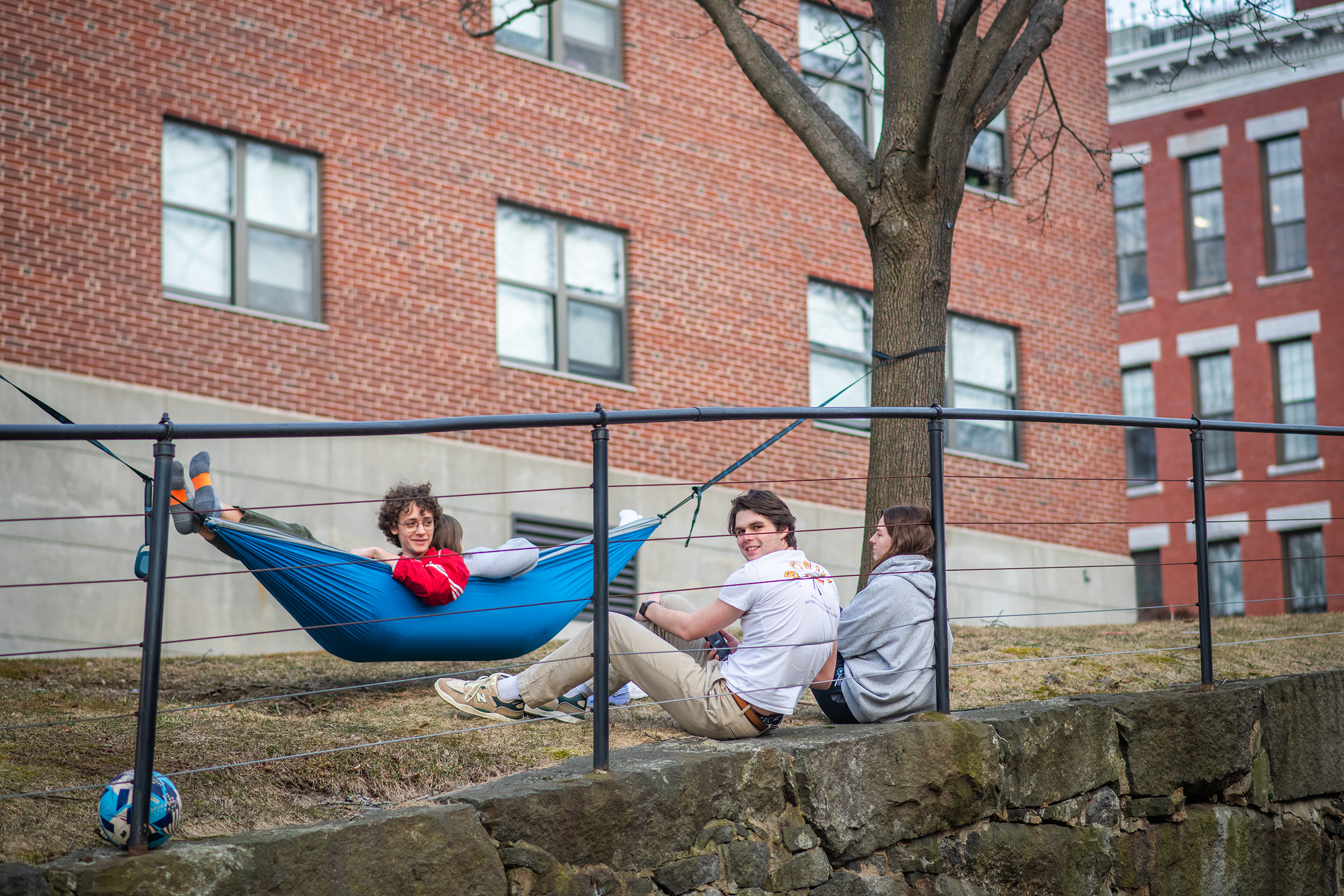 Student relaxing in a hammock next to Bullock Hall