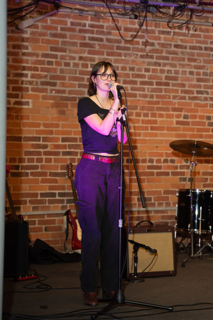 student sings into microphone