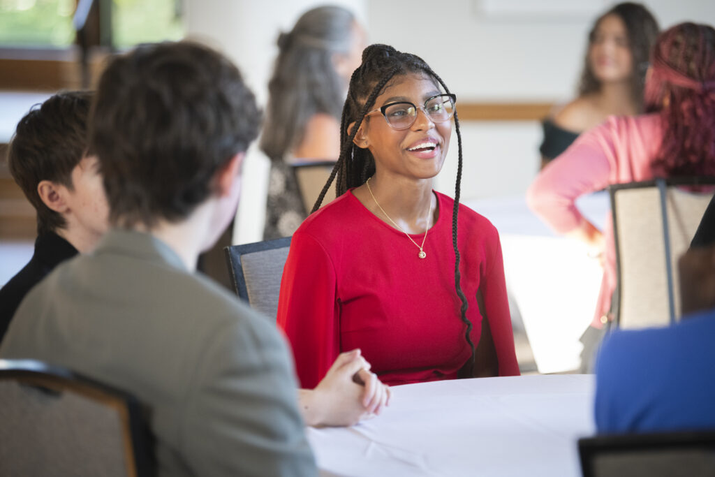 students sitting at table talk