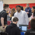 students and employers talk at career fair
