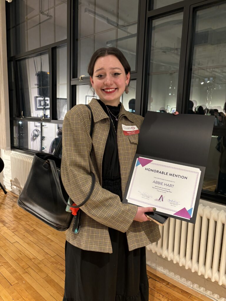 student holding certificate at gallery