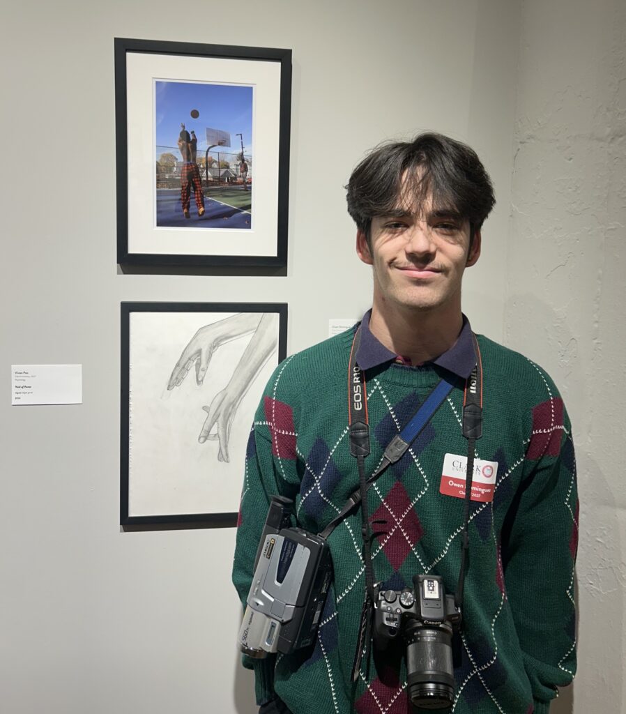 student poses with artwork at gallery