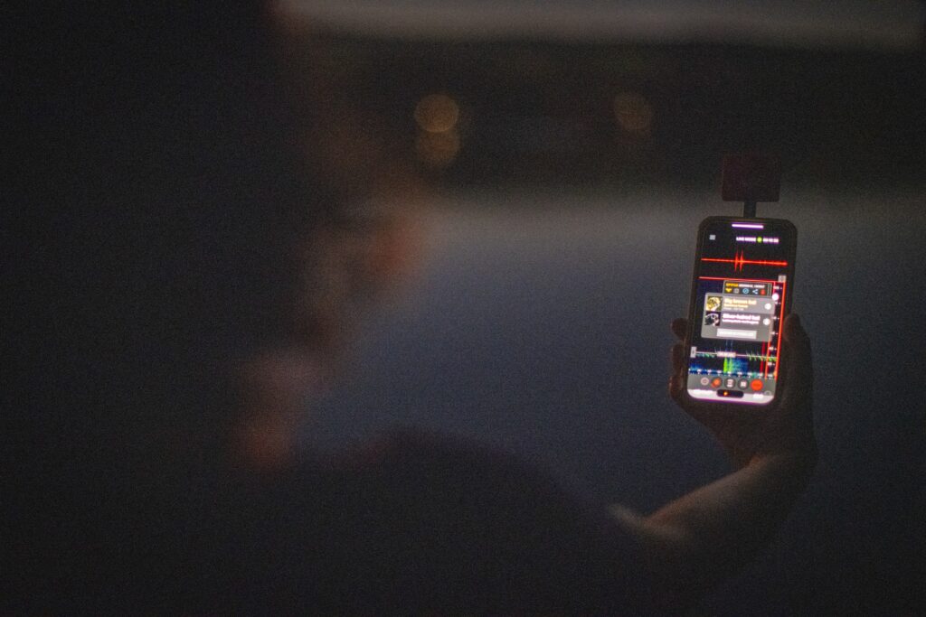 person holds phone at pond