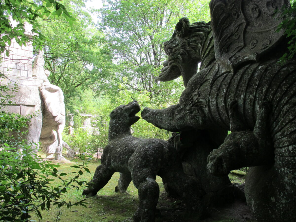 A sculpture of a dragon fighting with lions in Bomarzo, Italy