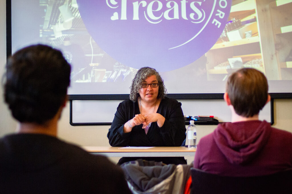 women sitting at table talks to students