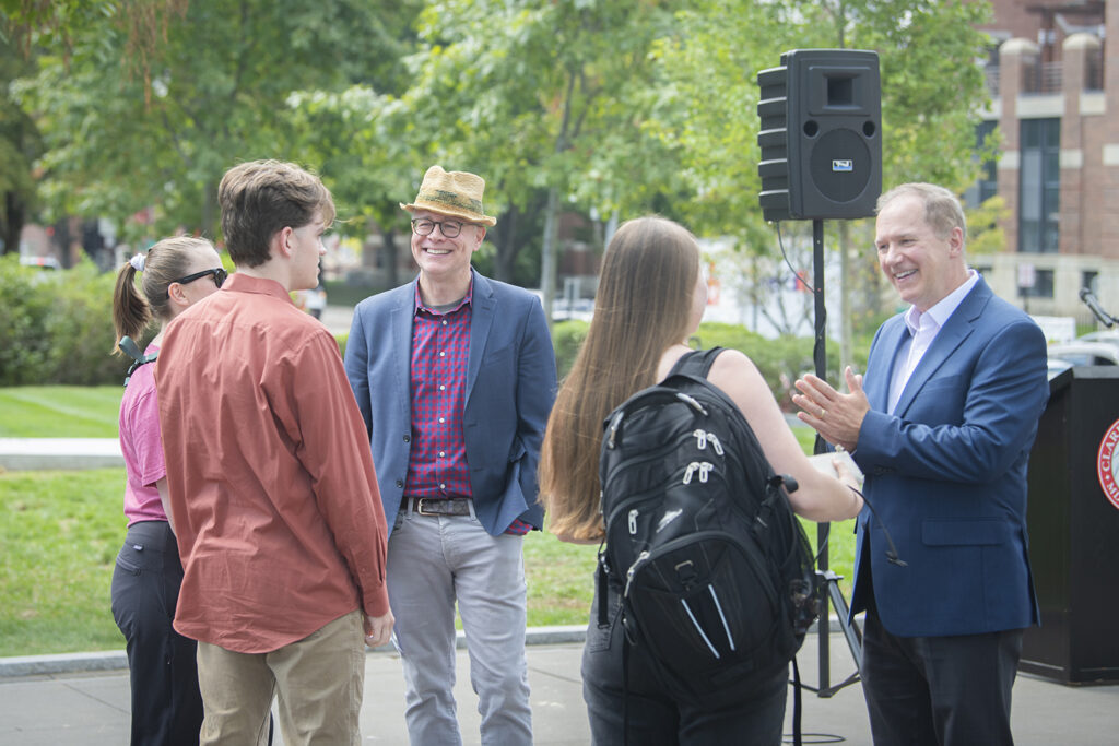 Dean Lou Leonard and President David Fithian speak with Clark students after planting a tree to celebrate the School of Climate, Environment, and Society.