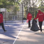 three people picking up trash