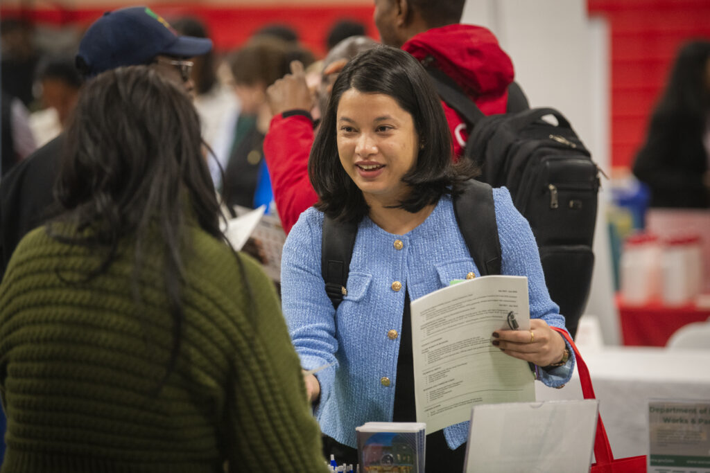 student shakes hand at career fair