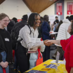 Student shakes employer's hand at spring 2025 career fair