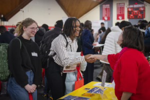 Student shakes employer's hand at spring 2025 career fair