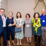 From left, members of the Economic Geography journal team celebrate its 100th anniversary at the 7th Global Conference on Economic Geography in June: former editor-in-chief and current book review editor Jim Murphy, managing editor Hilary Laraba, editor Karen Lai, editor-in-chief Siobhan McGrath, former editor-in-chief and current editorial board member Yuko Aoyama, and former editor and current editorial board member Henry Wai-Chung Yeung. (Photo by Nathan Fiske)