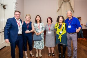 From left, members of the Economic Geography journal team celebrate its 100th anniversary at the 7th Global Conference on Economic Geography in June: former editor-in-chief and current book review editor Jim Murphy, managing editor Hilary Laraba, editor Karen Lai, editor-in-chief Siobhan McGrath, former editor-in-chief and current editorial board member Yuko Aoyama, and former editor and current editorial board member Henry Wai-Chung Yeung. (Photo by Nathan Fiske)