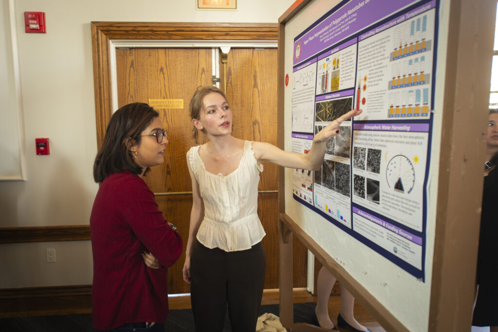 student shows research poster