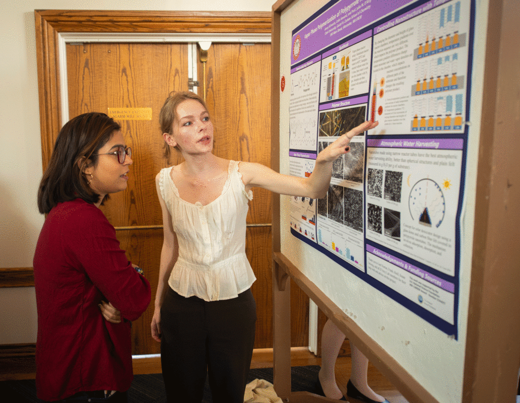 Avery Schwartz points to her research poster