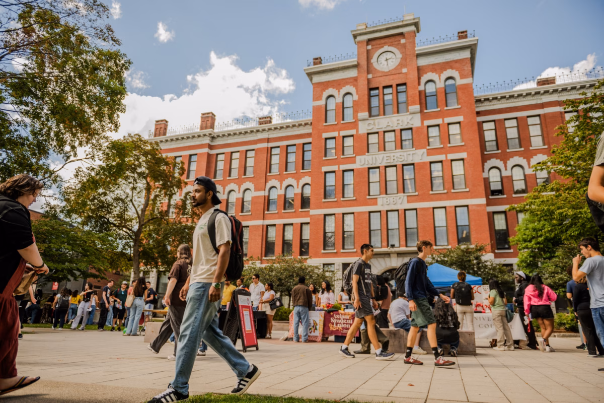 people walking on campus square in front of brick building