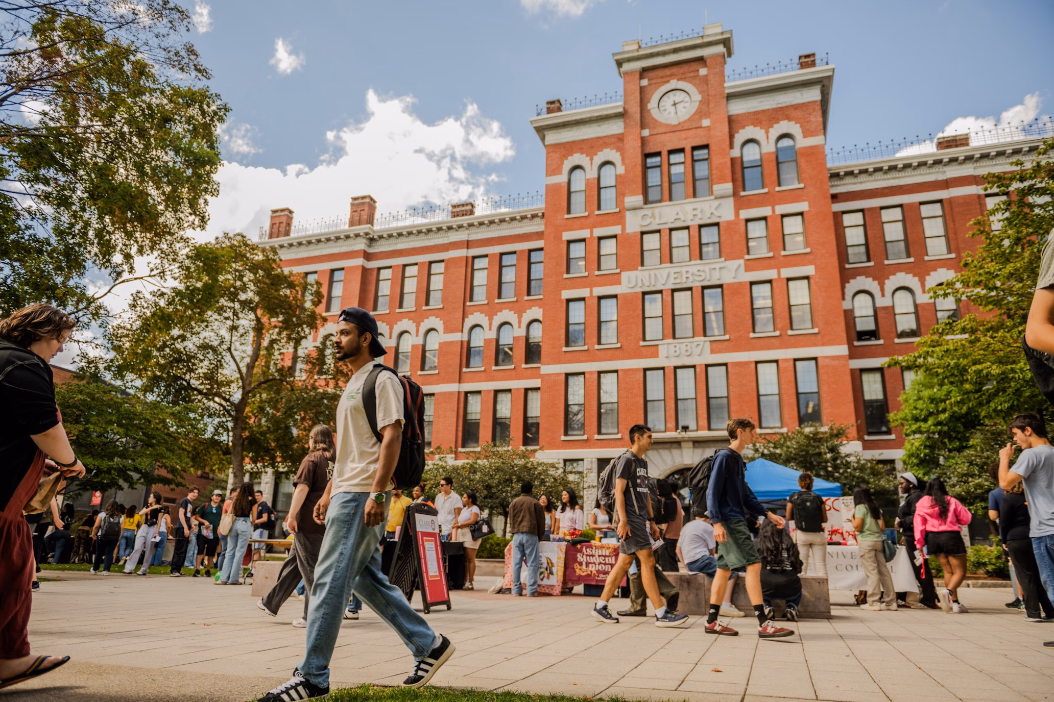 people walking on campus square in front of brick building