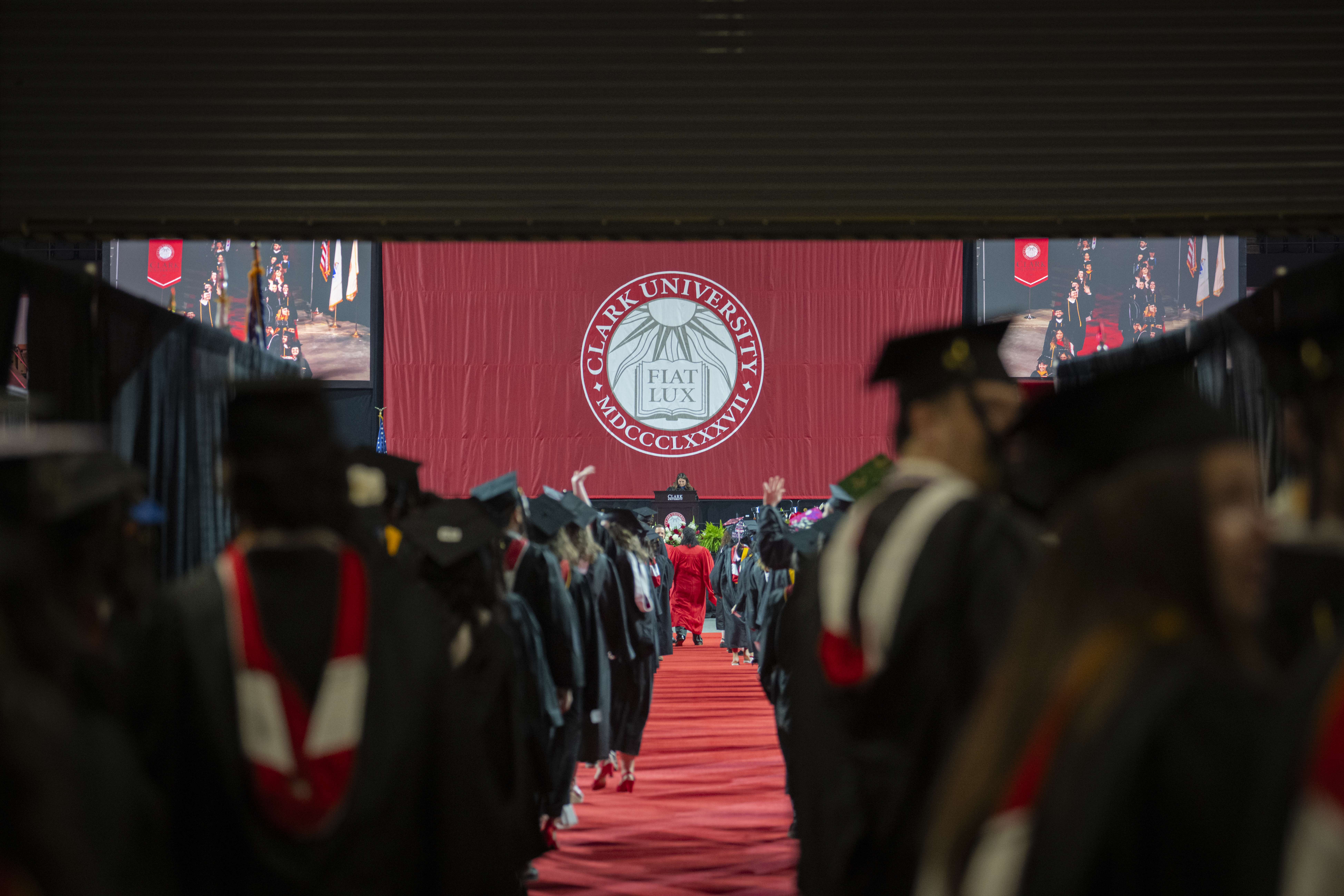 Two lines of students in graduation caps and gowns viewed from the end of the line