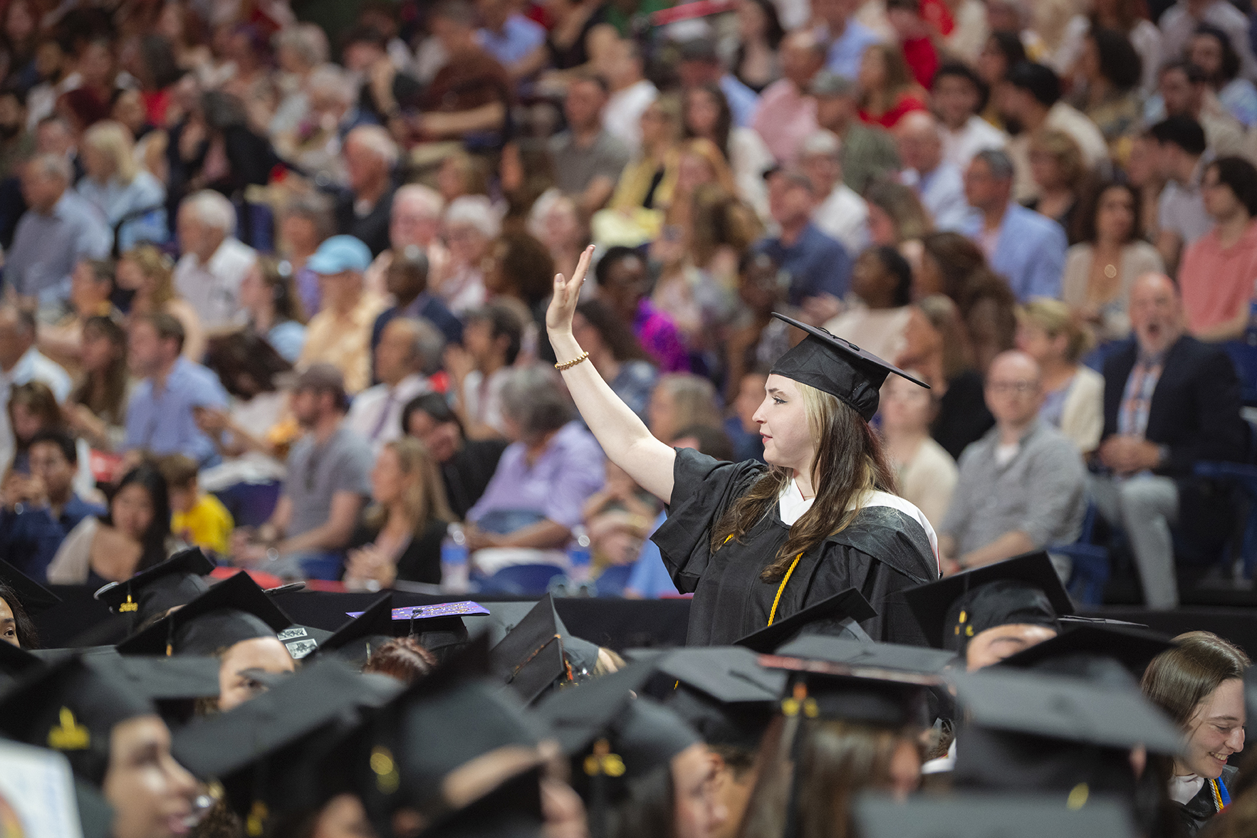 Student waves at Clark University commencement
