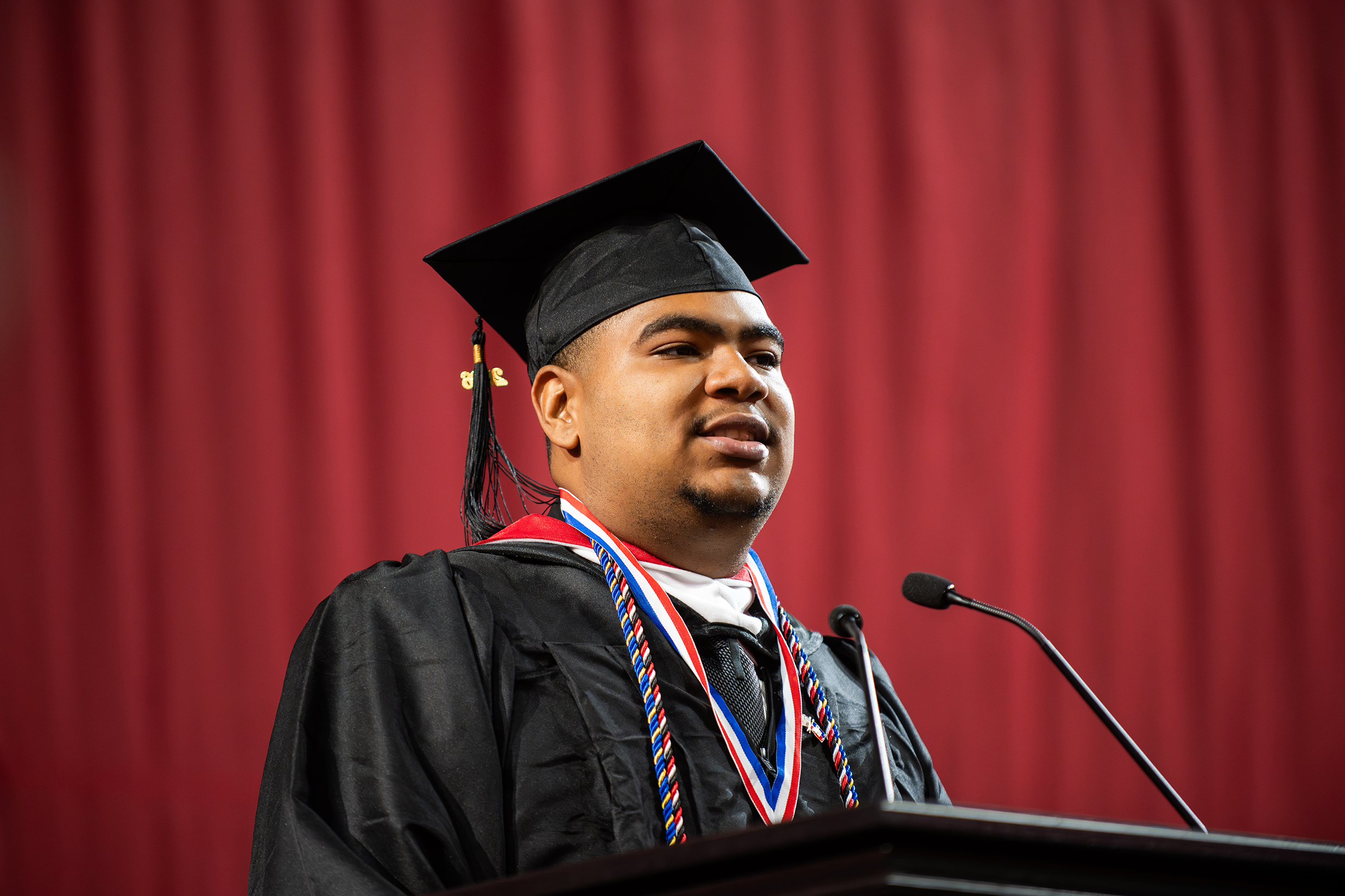 William Stafford stands at podium to deliver undergraduate student address
