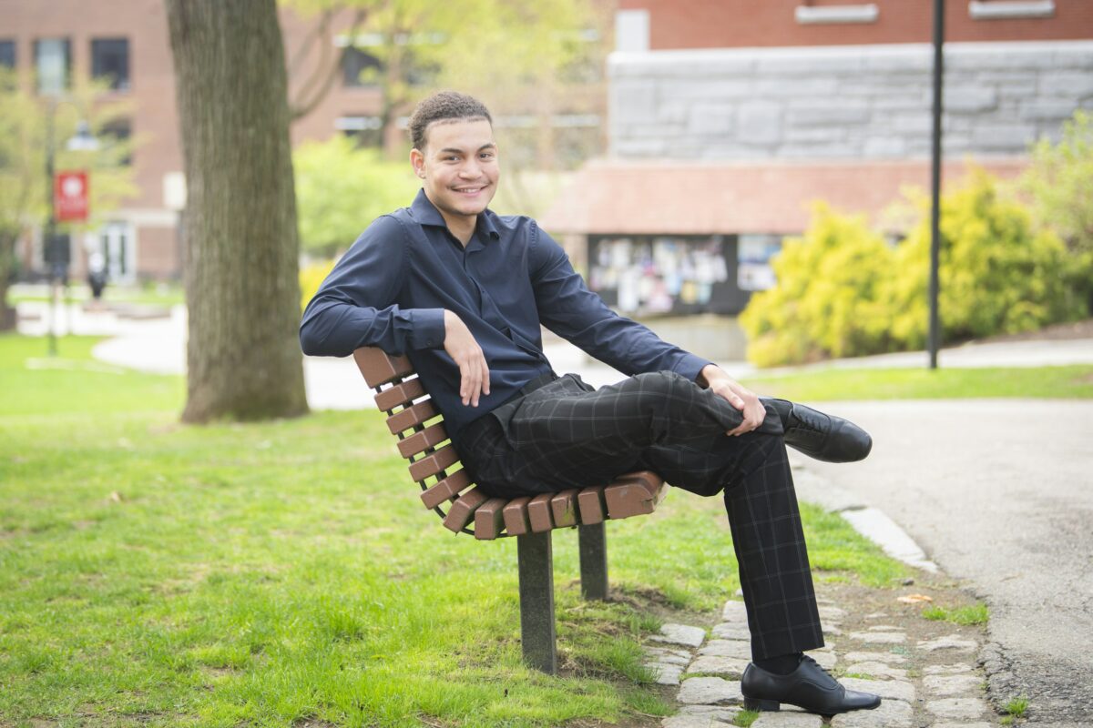 Debrin Adon Suero ’25 sitting on bench on Clark green