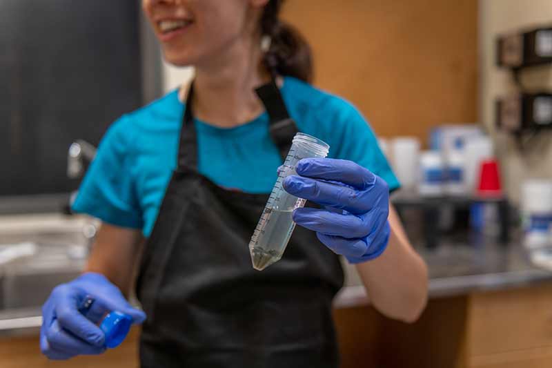 Erin McCullough holds a sample tube in the lab