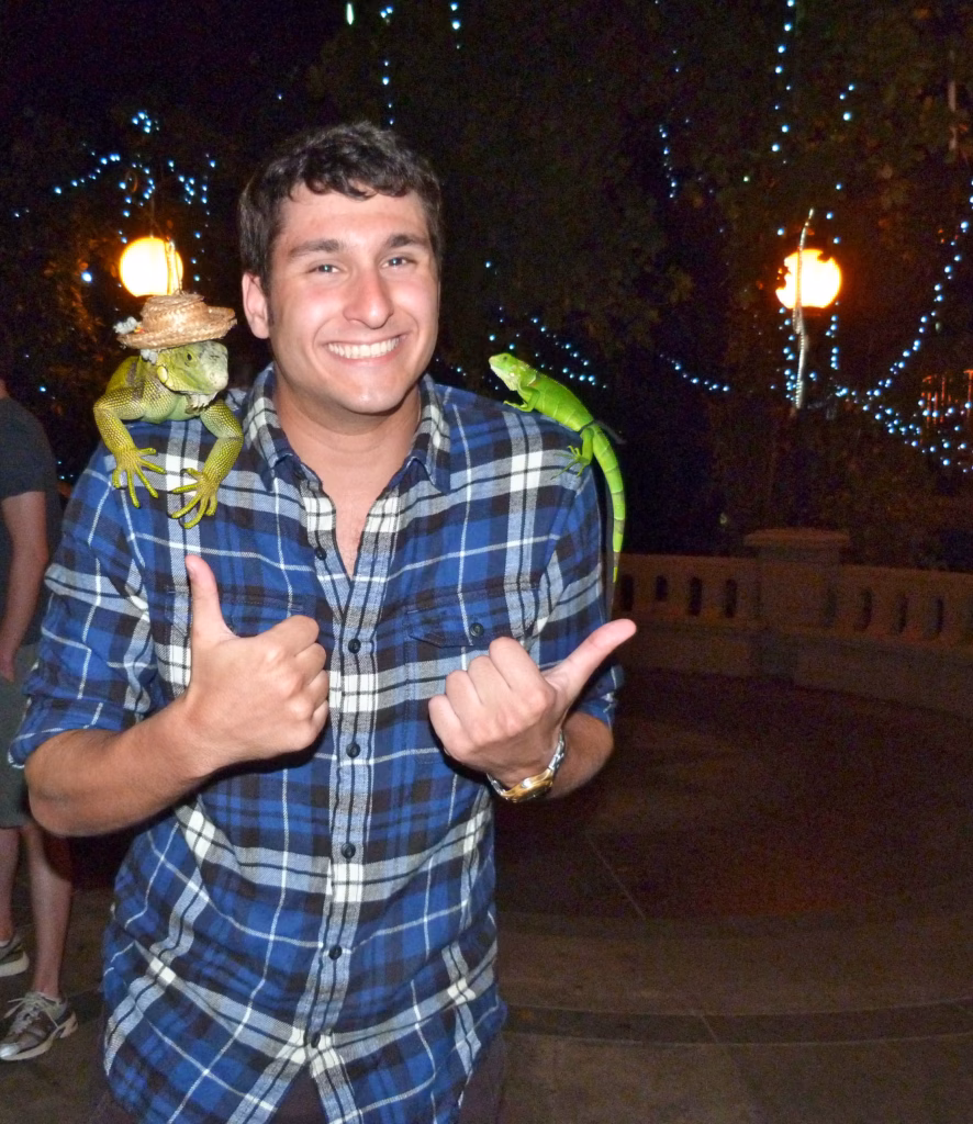 man in blue flannel shirt with an iguana sitting on each shoulder