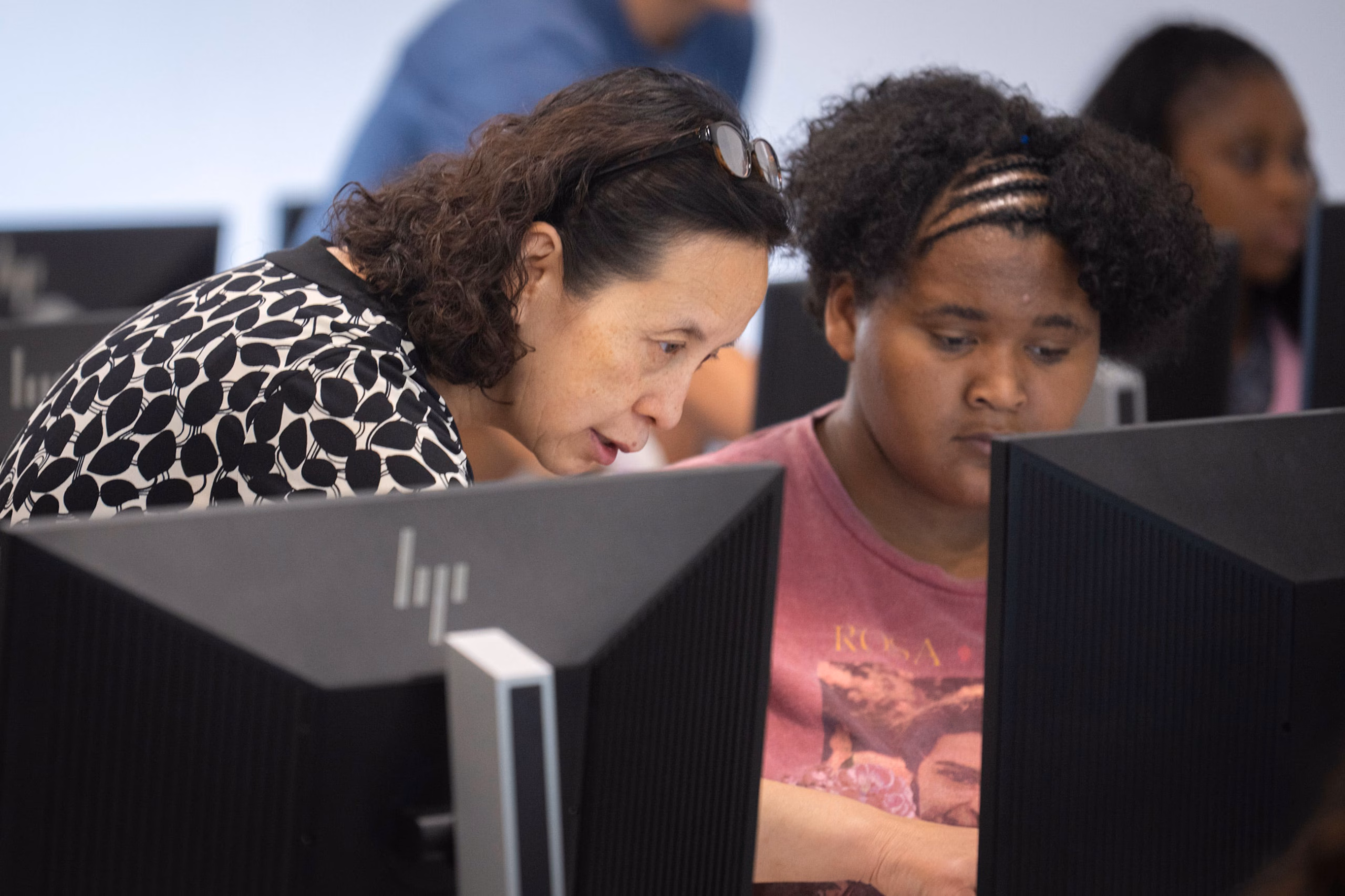 Li Han helping a middle school student at a computer