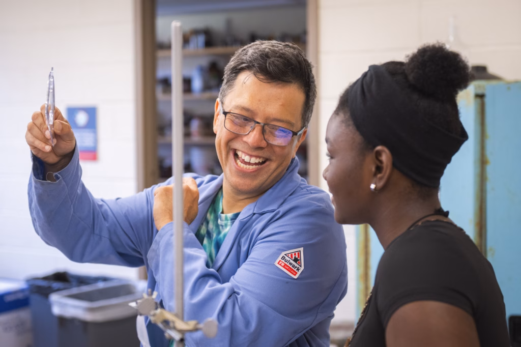 professor smiles while teaching student