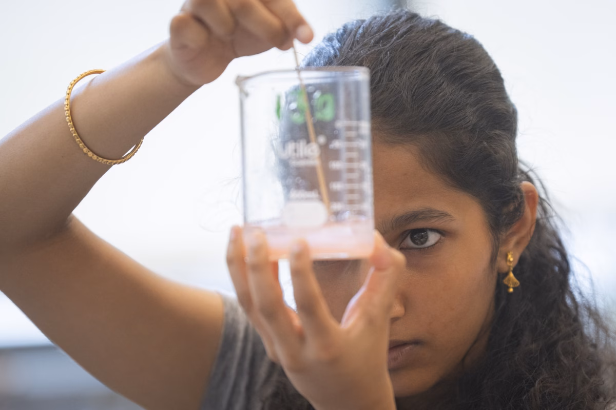 student mixes substance in beaker