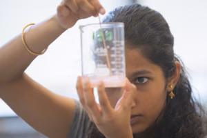 student mixes substance in beaker