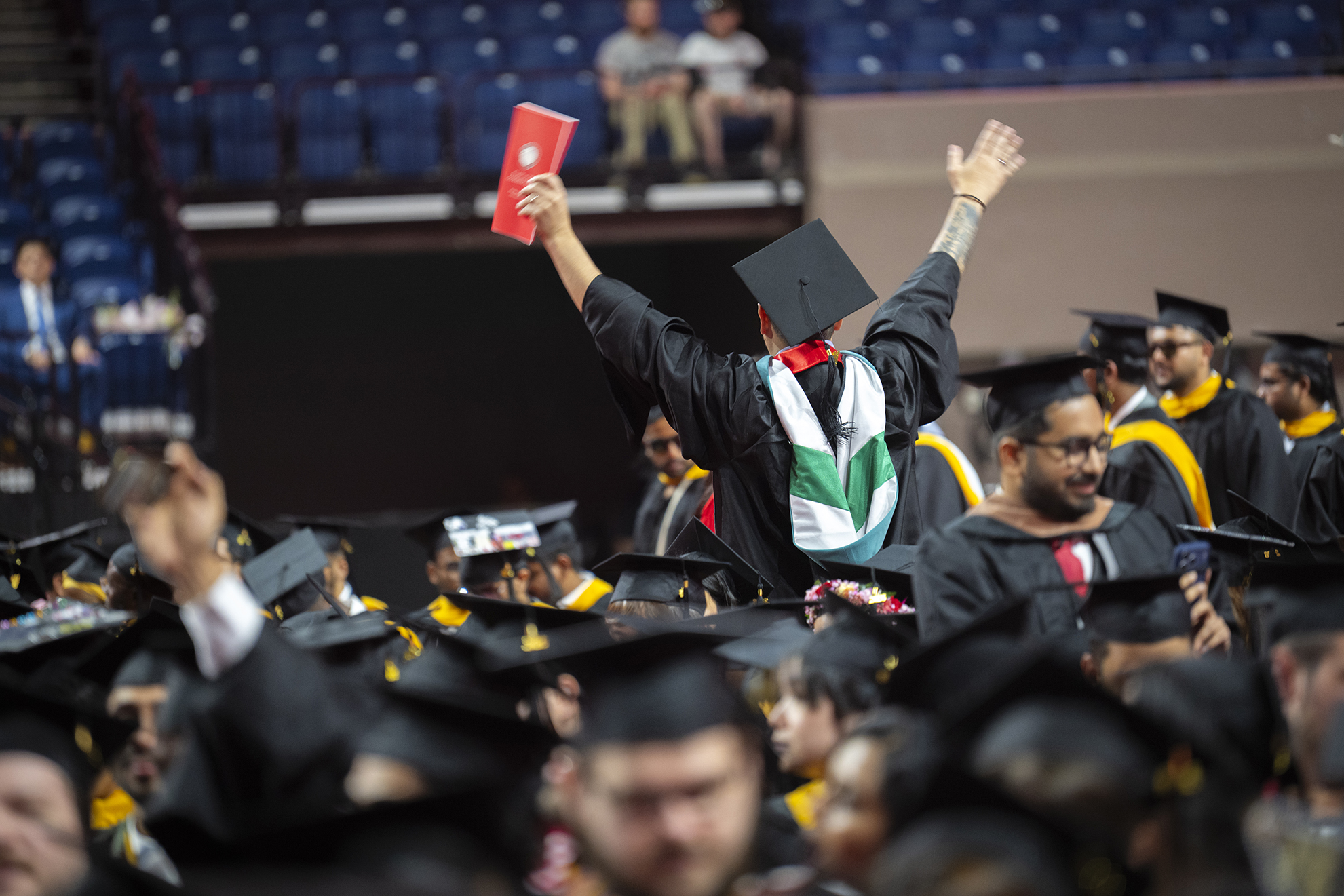 Graduating student waves at Clark University commencement