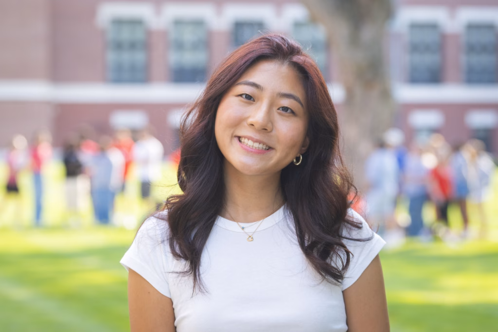 headshot of student in white T-shirt on campus green