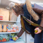 A student with the Clark University Hillel stocks a local community fridge.