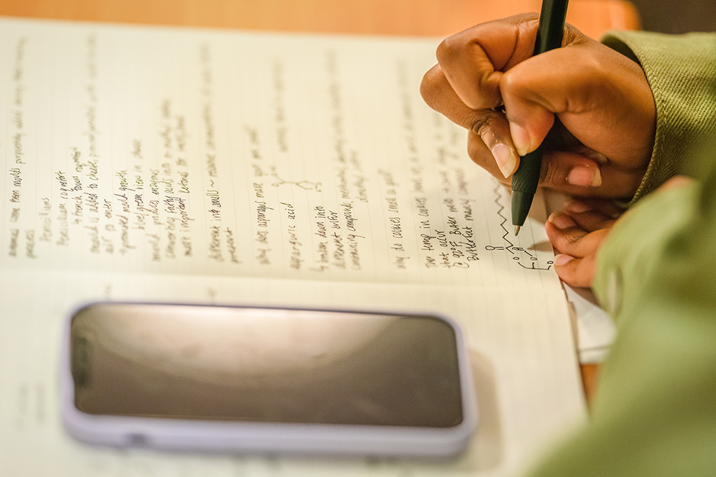 Clark student doing work in notebook
