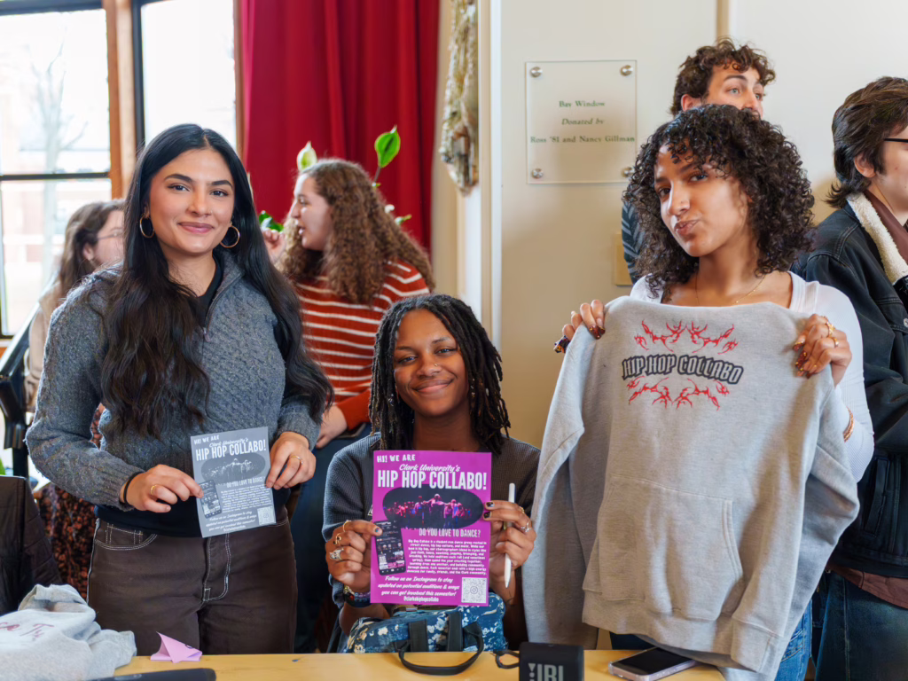 three people at table with poster